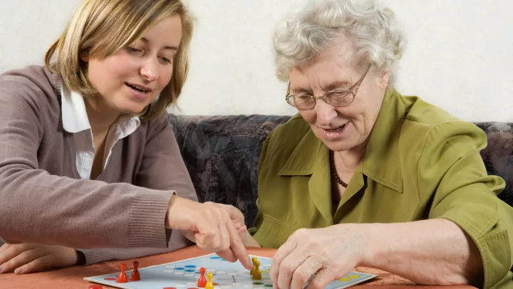 younger woman and elderly woman playing board game